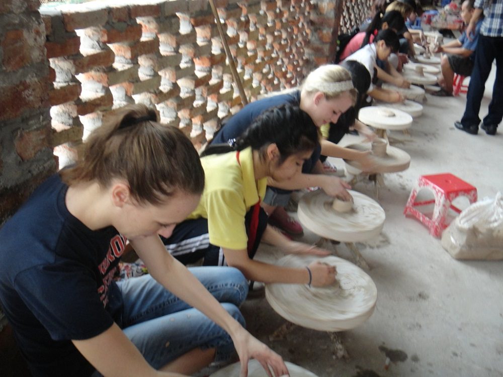 Tourist shaping clay at Bat Trang pottery workshop in Hanoi
