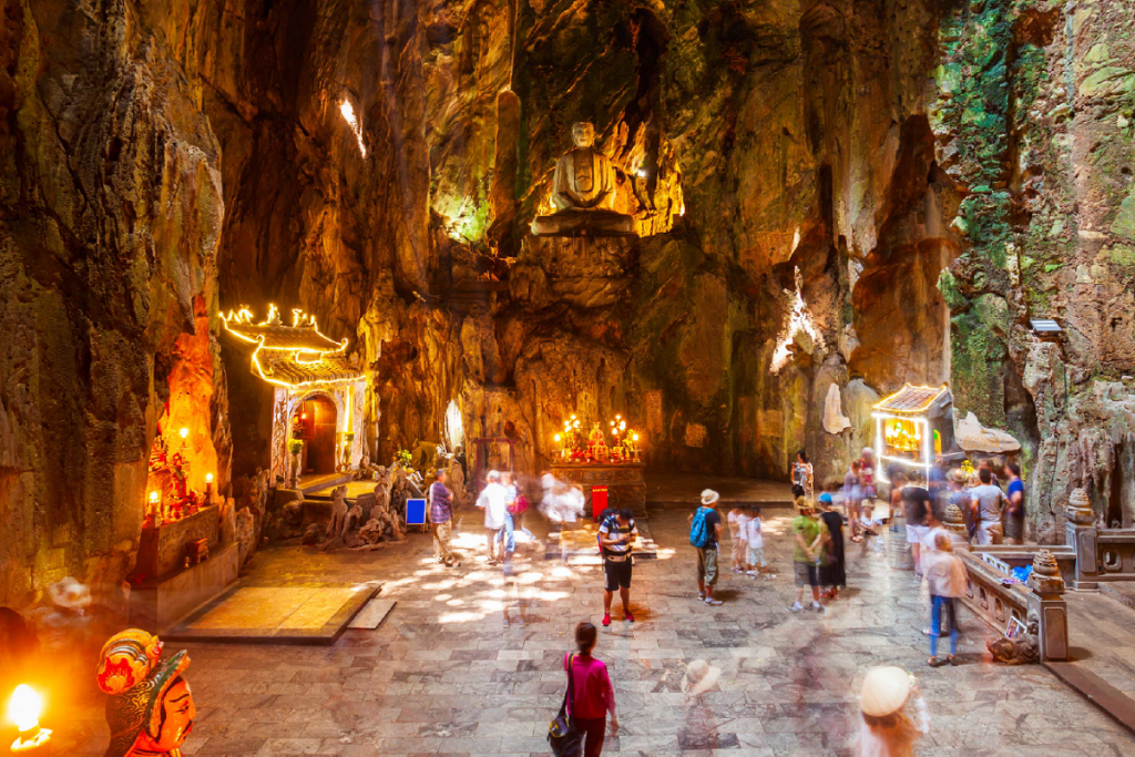 Inside Am Phu Cave in Marble Mountains showing Buddha statues and dimly-lit paths