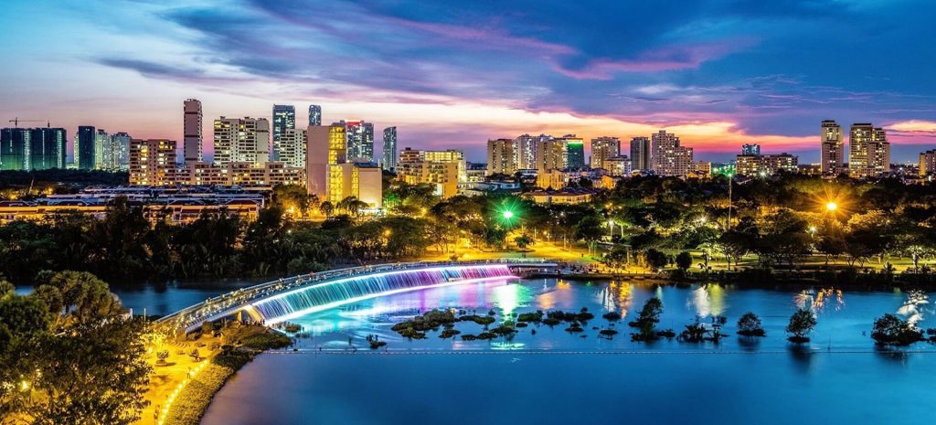 Starlight Bridge glowing with LED lights over Crescent Lake at night in Ho Chi Minh City