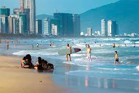 Tourists swimming at My Khe Beach in Danang under clear skies