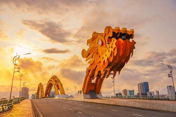 Danang Dragon Bridge lit up in yellow lights at night