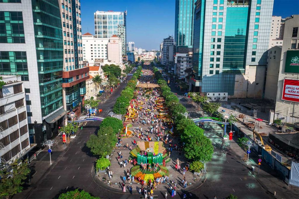 Nguyen Hue Walking Street at night with people, lights, and Saigon skyline