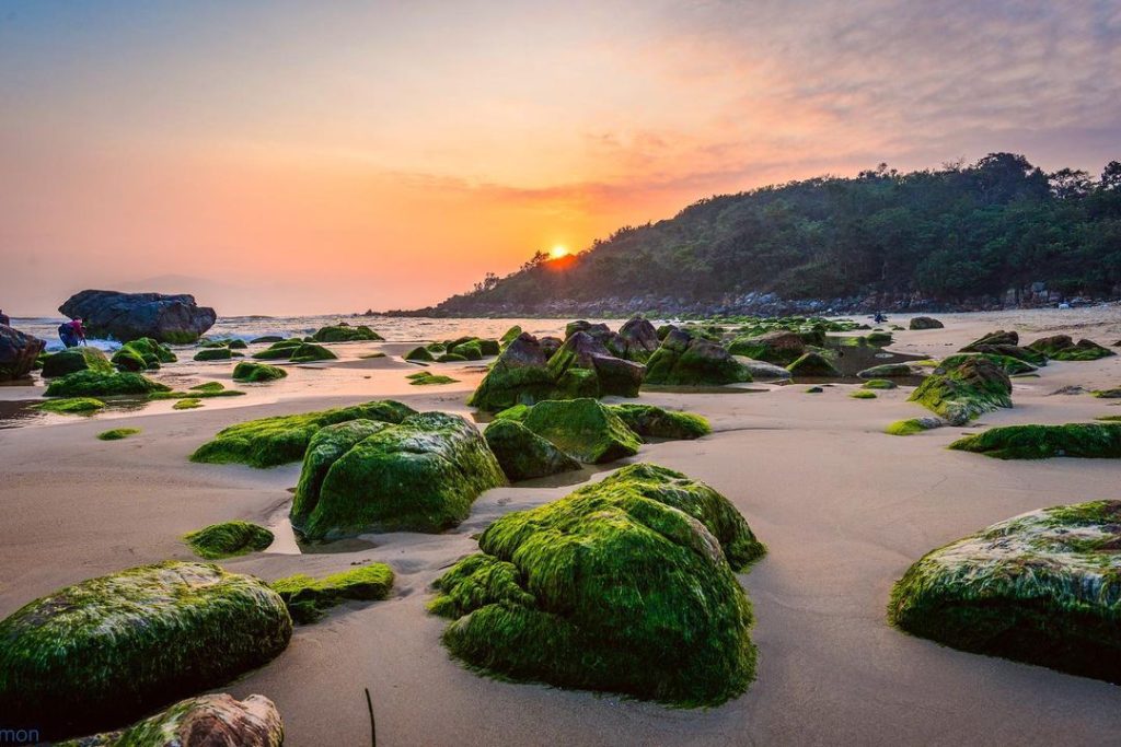 Sunset over Nam O Beach in Da Nang with gentle waves and colorful sky