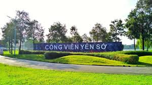 Yen So Park in Hanoi with lake, trees, and people cycling on a sunny day