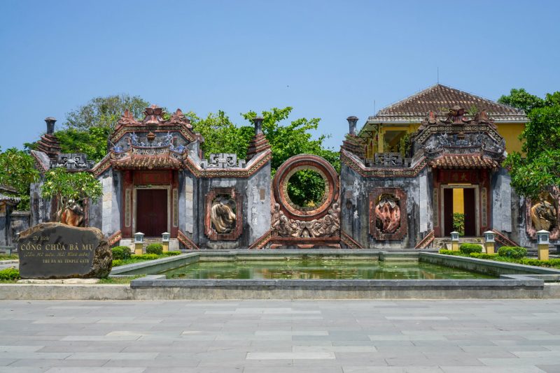 Ba Mu Temple main gate with pink walls and decorative arches in Da Nang, Vietnam