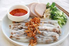 Close-up of Thanh Tri steamed rice rolls with dipping sauce and herbs