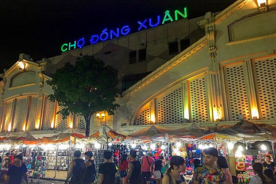Busy entrance of Dong Xuan Market with locals and tourists shopping in Hanoi