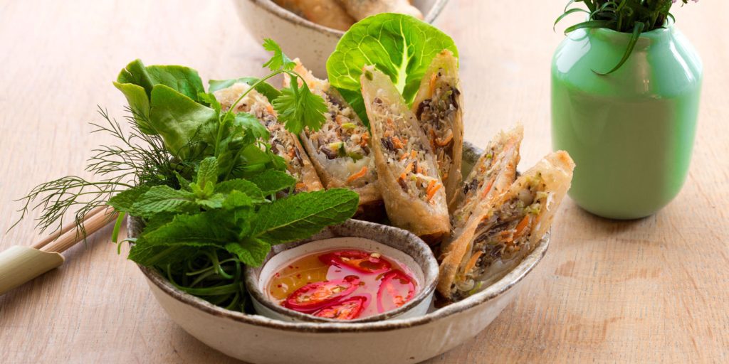 Golden crispy Vietnamese spring rolls served with dipping sauce