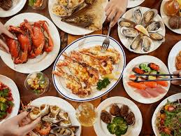 Colorful buffet spread with seafood, sushi, and grilled meats