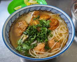 Fresh herbs and vegetables served with fish cake noodle