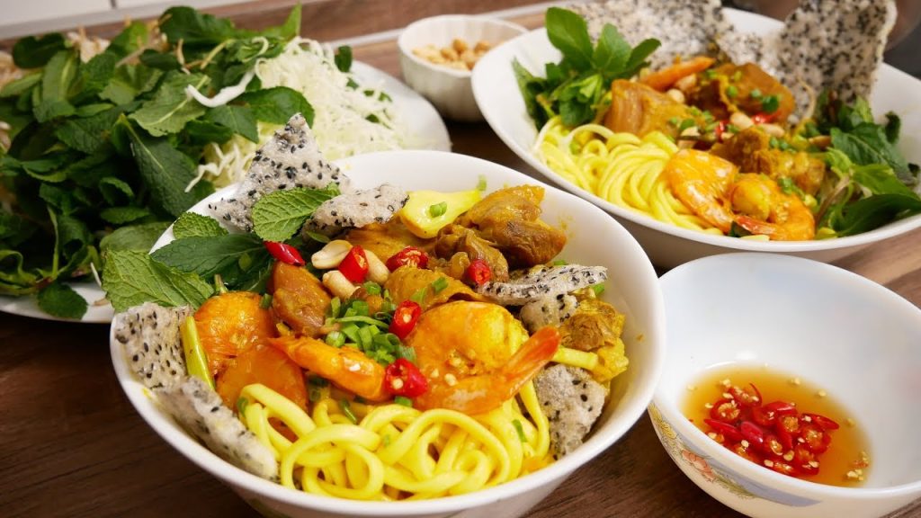 A delicious bowl of Mi Quang noodles in Da Nang with herbs and pork