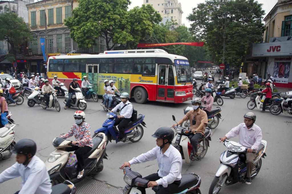 Hanoi street with buses, taxis, and motorbikes in motion